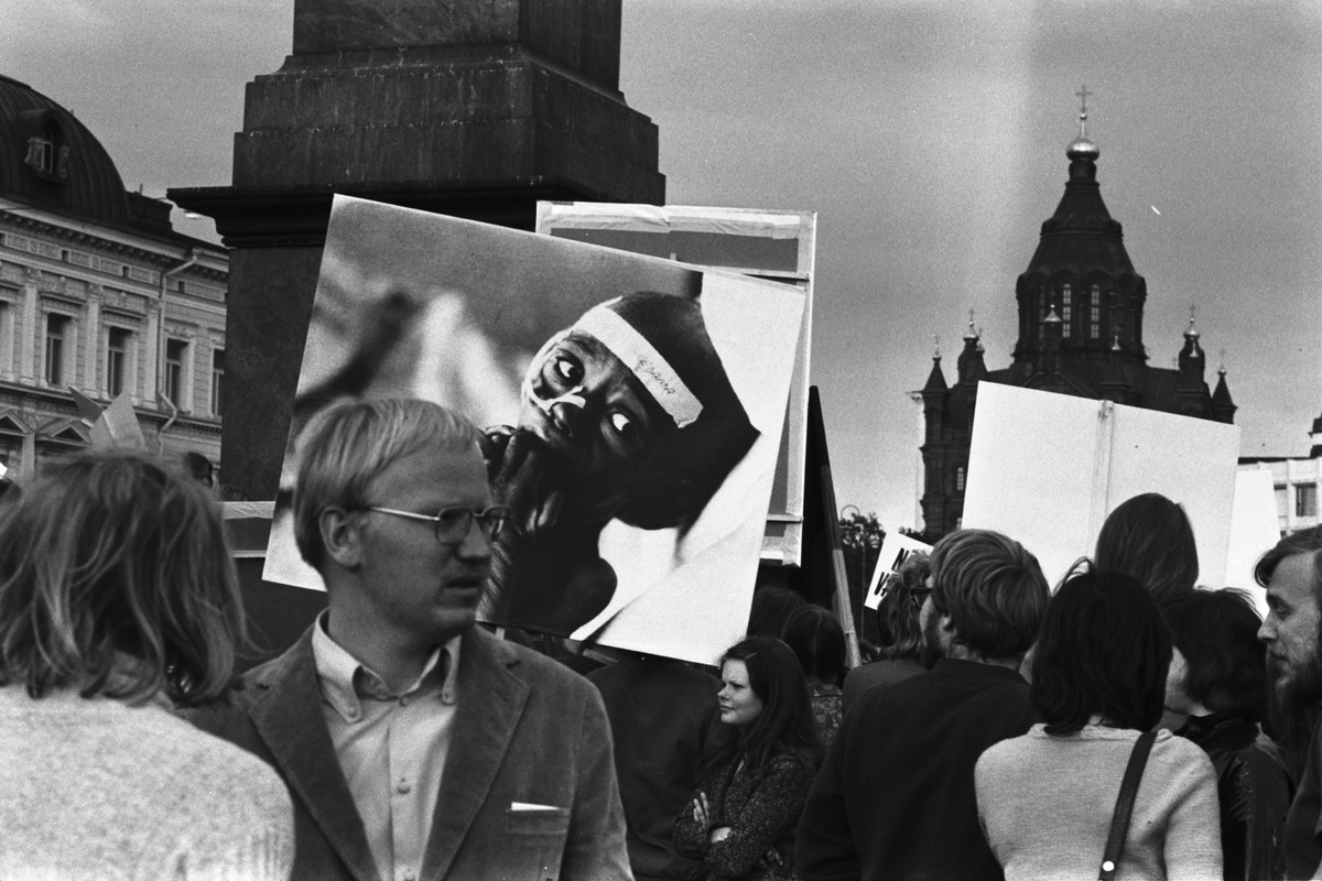 hmisiä plakaatteineen Etelä-Afrikan rotusorron, apartheidin vastaisessa mielenosoituksessa Kauppatorilla Keisarinnankiven luona. Taustalla Uspenskin katedraali.
