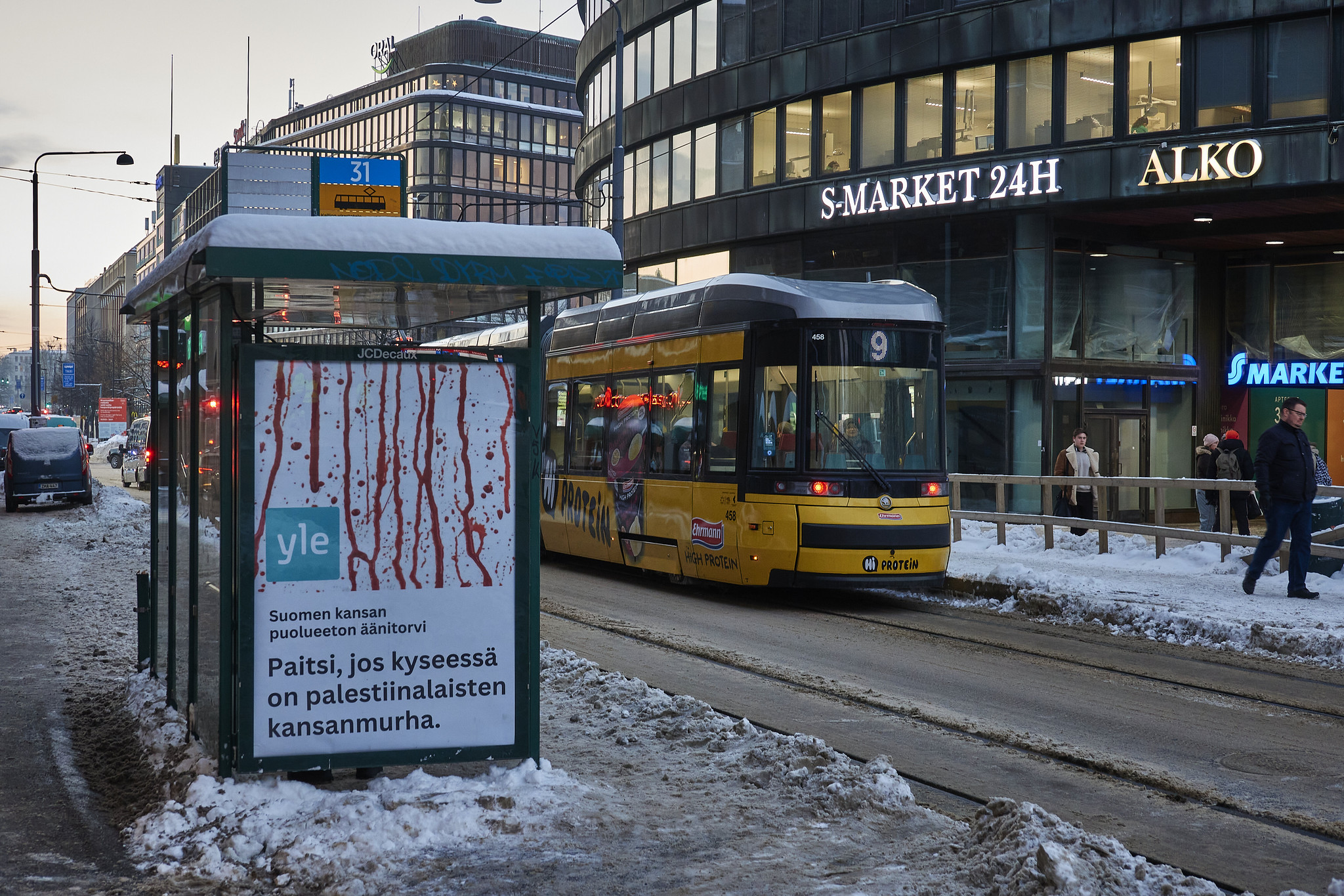 yle-antimainos-palestiina-gaza-rajatonvimma Raitiovaunupysäkki ja raitiovaunu talvisella kadulla.